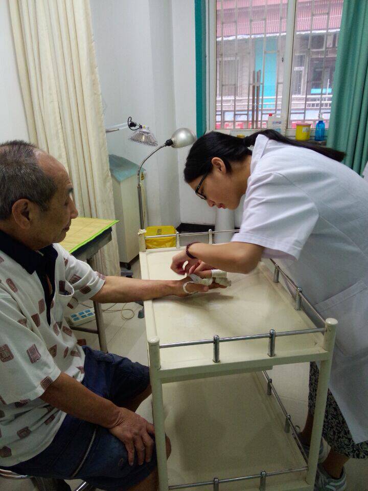 C:\Users\Administrator.WIN7U-20140714N\Desktop\临床医学院与基层医疗行业紧密合作，开展全科学生暑期带薪实习\实习学生为患者包扎.jpg